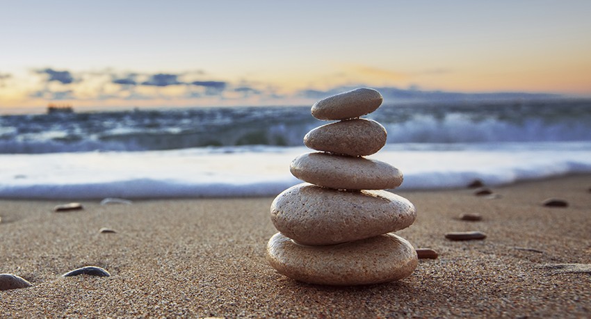 Stones balance on beach at sunrise