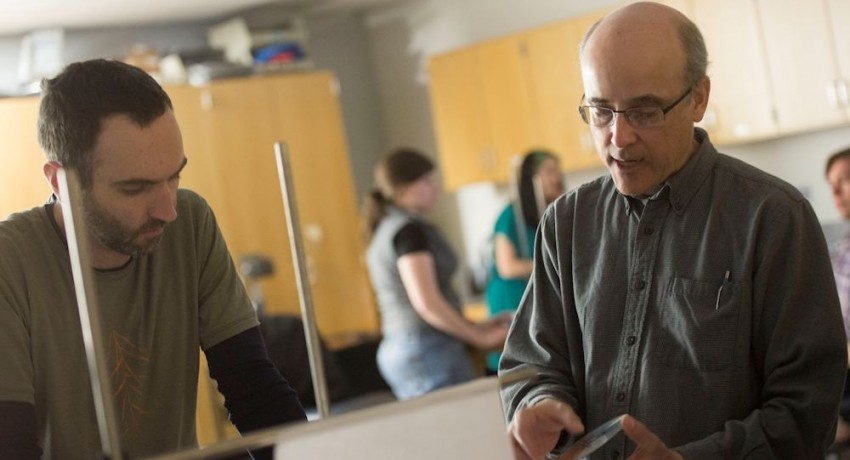 Worcester State University Associate Professor of Physics Frank Lamelas helps a student during a lab.