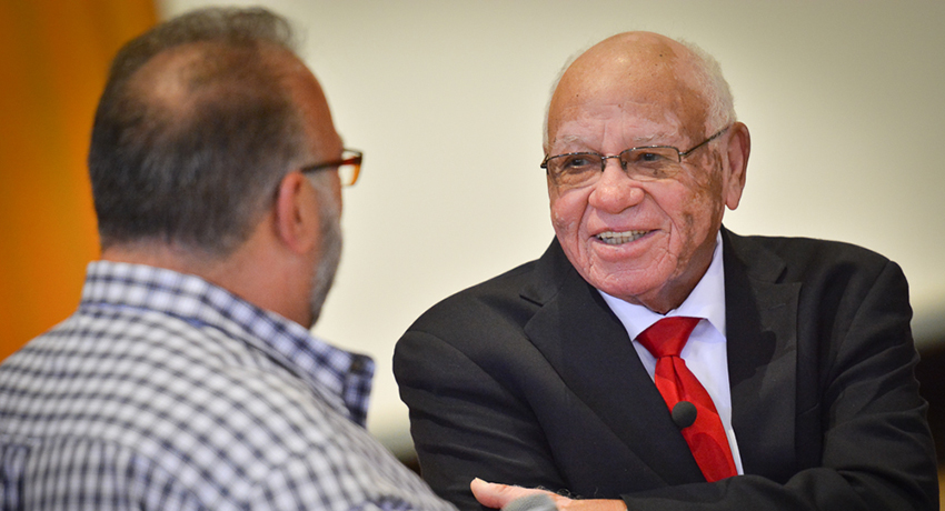 Herman Boone listens to an audience member after his talk at Worcester State University.