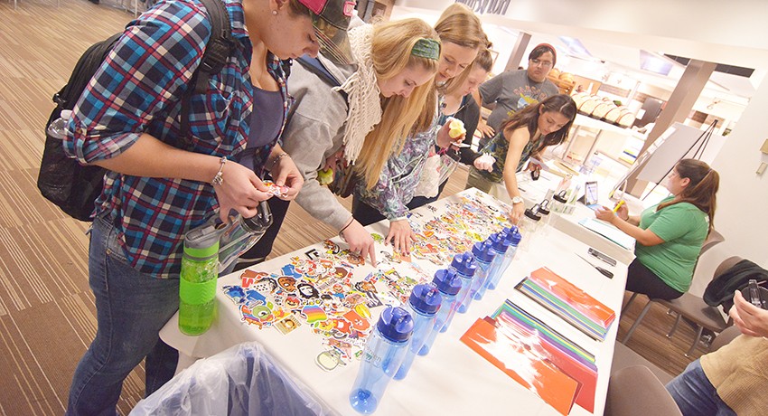 Worcester State University students decorate water bottles at Sustainability and Food Fair.