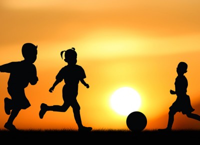 Silhouette of the children play with ball at sunset.
