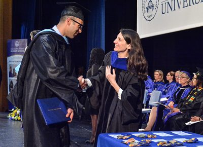 A student receives a degree at the 2017 Worcester State University Graduate School commencement.
