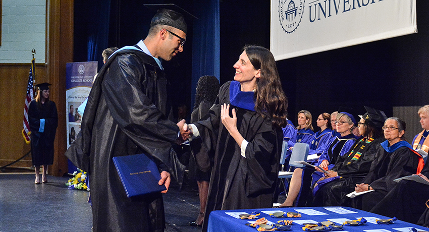 A student receives a degree at the 2017 Worcester State University Graduate School commencement.