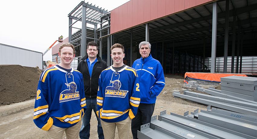 A few members of the Worcester State University men's hockey team and coaches in front of new ice rink