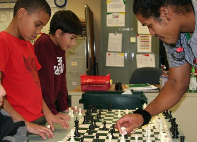 Worcester State senior Diallo Frys plays chess with City View students.