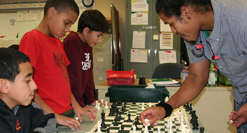 Worcester State senior Diallo Frys plays chess with City View students.