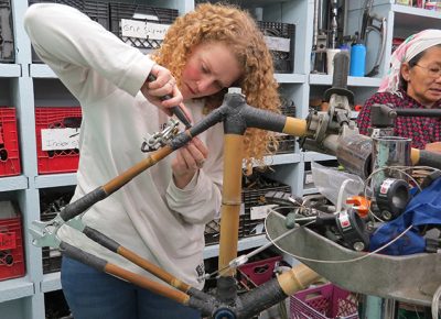 A participant in the Worcester bamboo bike workshop works on a bike.