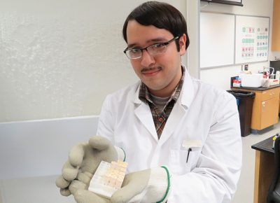 Worcester State biotech major Will Rodriguez holds Antarctica soil samples.