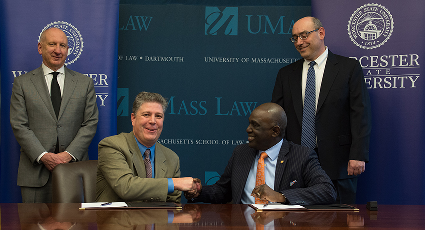 Worcester State President Barry Maloney shakes hands with UMass Dartmouth Chancellor Robert Johnson.